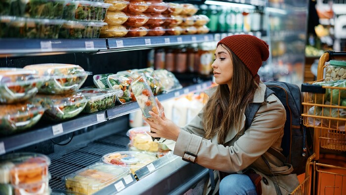 © Drazen, stock.adobe.com Junge Frau kauft im Supermarkt abgepacktes Gemüse