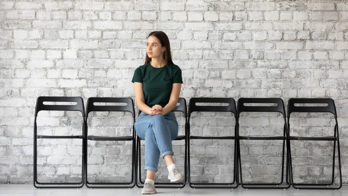 Junge Frau sitzt auf einem Stuhl