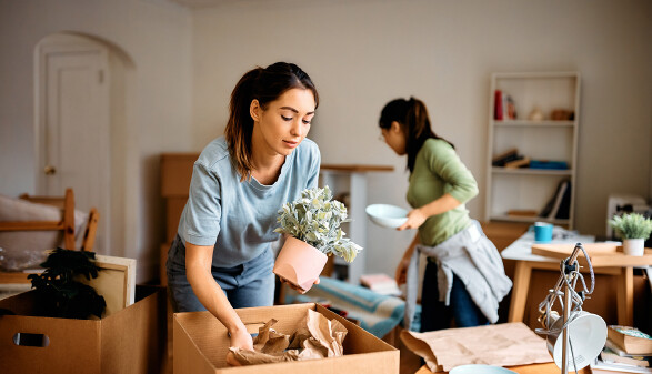 Zwei junge Frauen packen Umzugskisten
