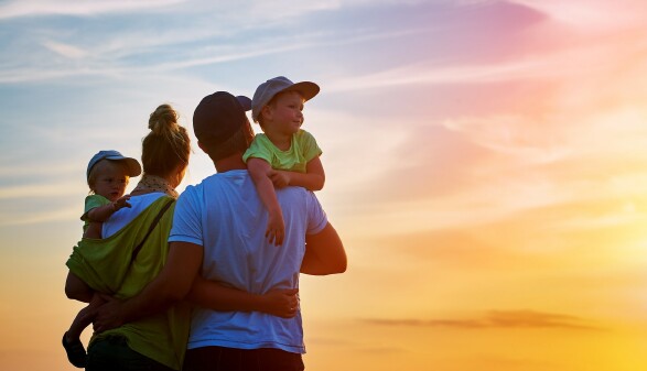 Vater, Mutter und zwei Kinder bei Sonnenuntergang
