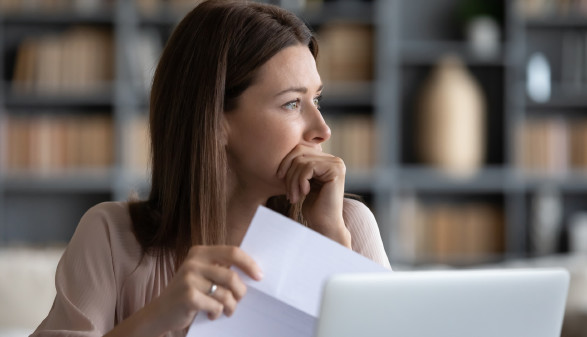 Frau hält nachdenklich Brief in der Hand