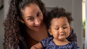 Lachende Mutter mit ihrem Baby