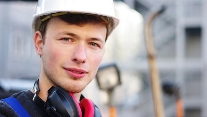 Junger Baumaschinentechniker auf der Baustelle