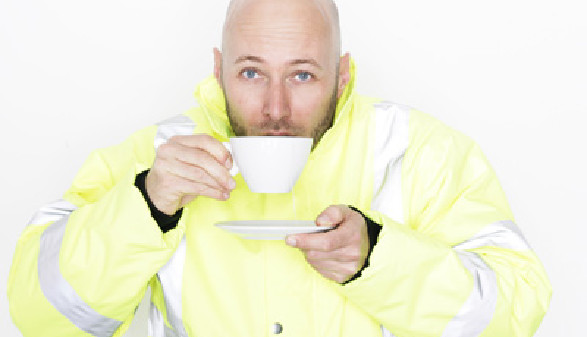 Ein Mann in Arbeitskleidung nippt an einer Tasse Tee, in der anderen Hand hält er die Untertasse. © stock.adobe.com