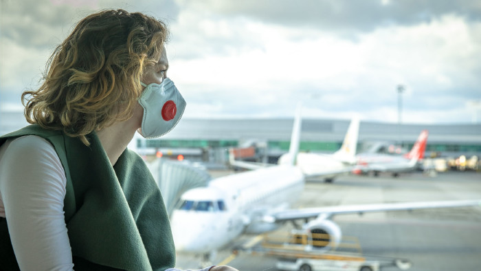 © edojob , stock.adobe.com Frau mit Mundschutz blickt auf Flughafen © edojob , stock.adobe.com
