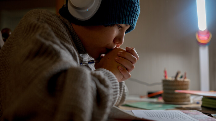© Анастасия Амраева, stock.adobe.com Ein Teenager macht seine Hausaufgabe in einer ungeheizten Wohnung.