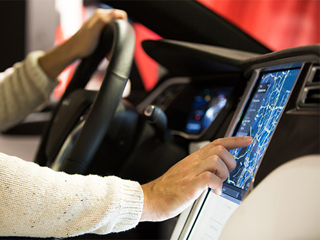 Das Innere eines Tesla Model X Elektroautos mit großem Touchscreen. Die Hand des Fahrers bedient das GPS Navigationssystem © ladysuzi, Fotolia.com Tesla © ladysuzi, Fotolia.com