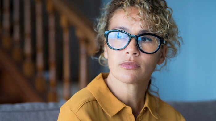Nahaufnahme des Gesichts einer nachdenklichen Frau mit Brille