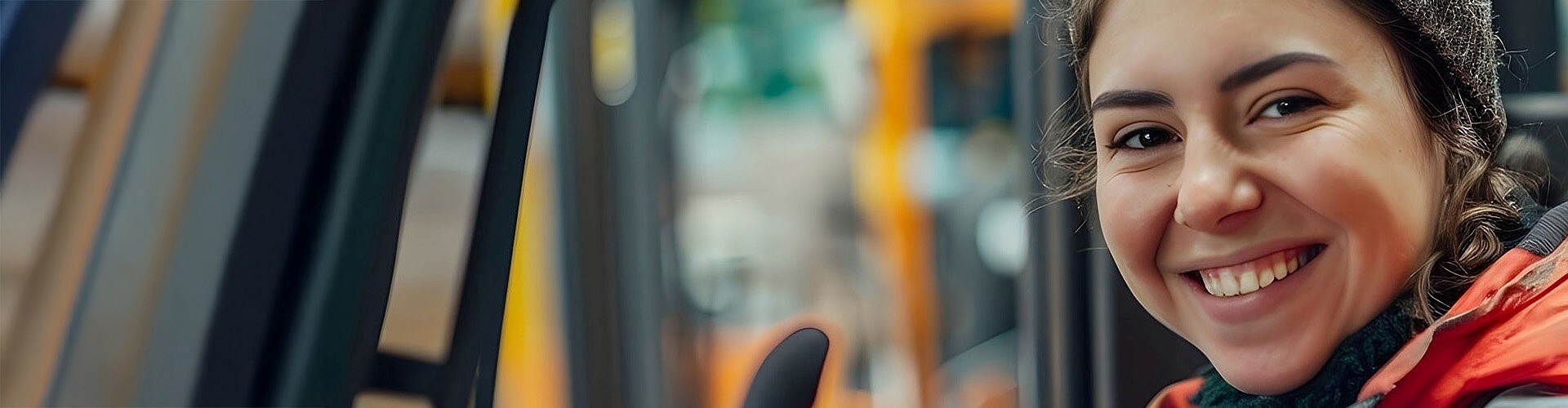 Junge Arbeiterin fährt einen Gabelstapler