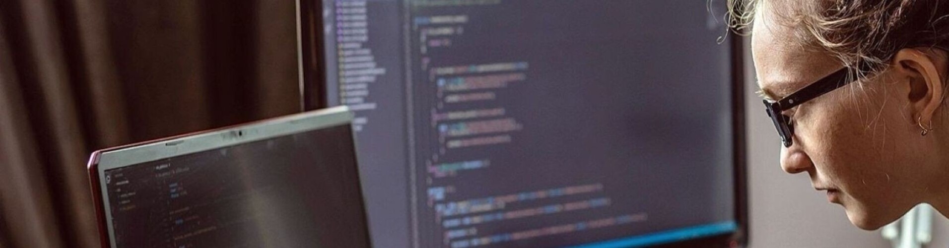 Eine junge Programmiererin schreibt einen Programmcode auf ihrem Laptop