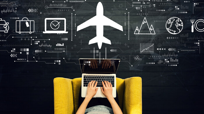 Flight ticket booking concept with person using a laptop in a chair