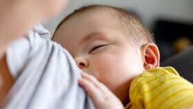 Schlafendes Baby an der Brust