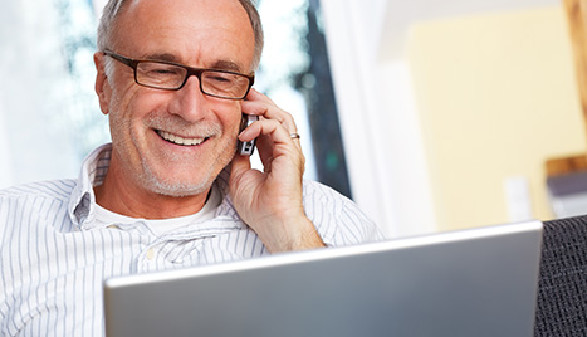 Mann mit Brille sitzt vor Laptop und telefoniert © Günter Menzl, Fotolia