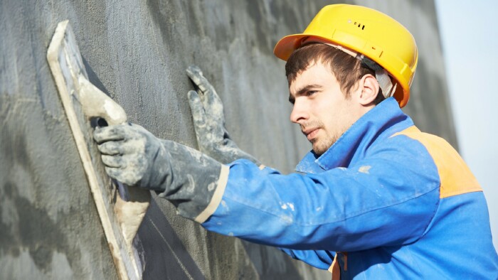 Bauarbeiter bei Verputzarbeiten an der Fassade