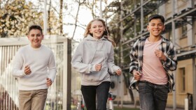 3 Jugendliche laufen die Straße entlang