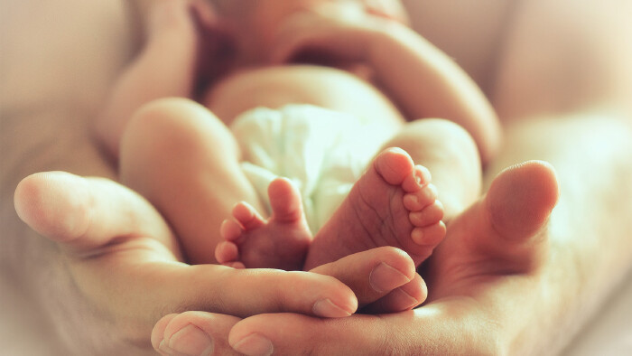 Eltern halten ein schlafendes Neugeborenes in ihrer Hand © Zffoto, stock.adobe.com