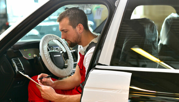 KFZ Mechaniker kontrolliert Auto