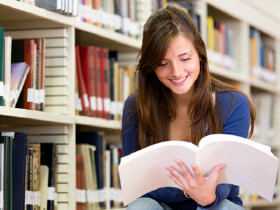 Studentin informiert sich in der Bibliothek