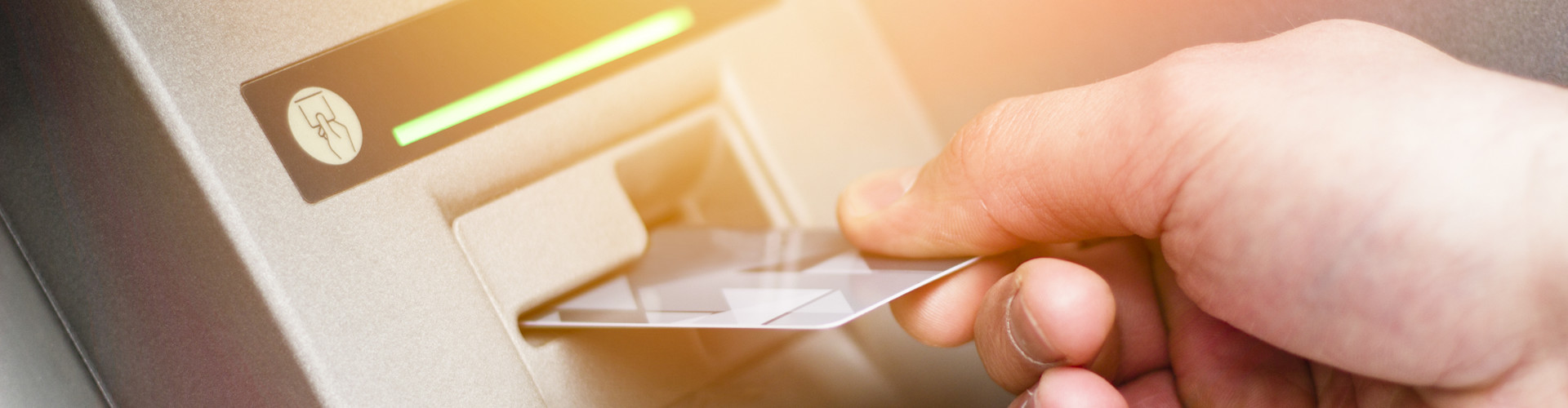 Man sieht die Hand eines Mannes, der eine Bankkarte in einen Bankomaten einführt. © Addoro, stock.adobe.com
