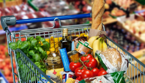 Ein voller Einkaufswagen im Supermarkt, im Hintergrund sieht man unscharf das Gemüseregal © Eisenhans, stock.adobe.com