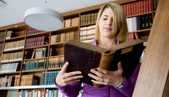 Junge Frau blättert in einem Buch © Lisi Specht