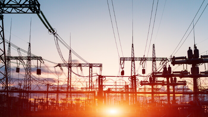 The silhouette of the evening electricity transmission pylon