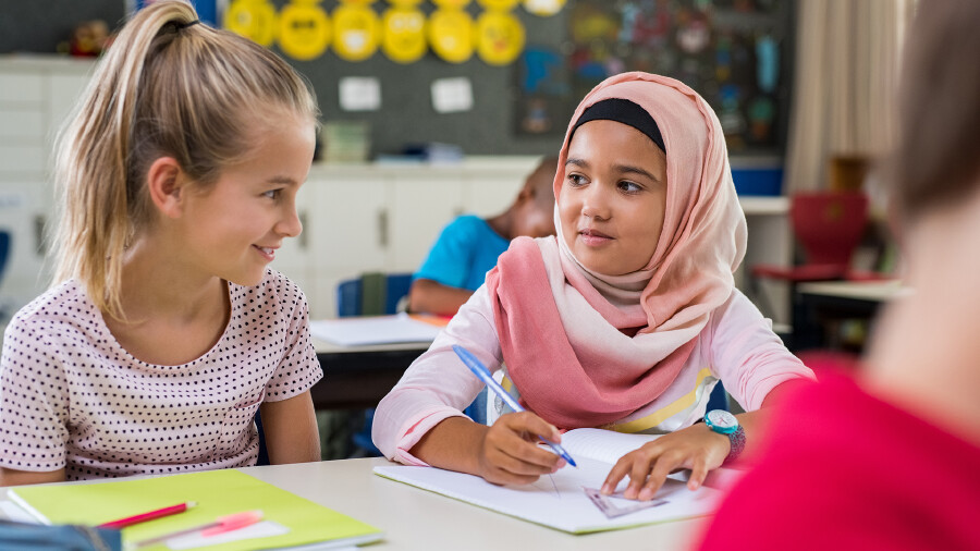 Mädchen mit Kopftuch mit Freundin in der Klasse