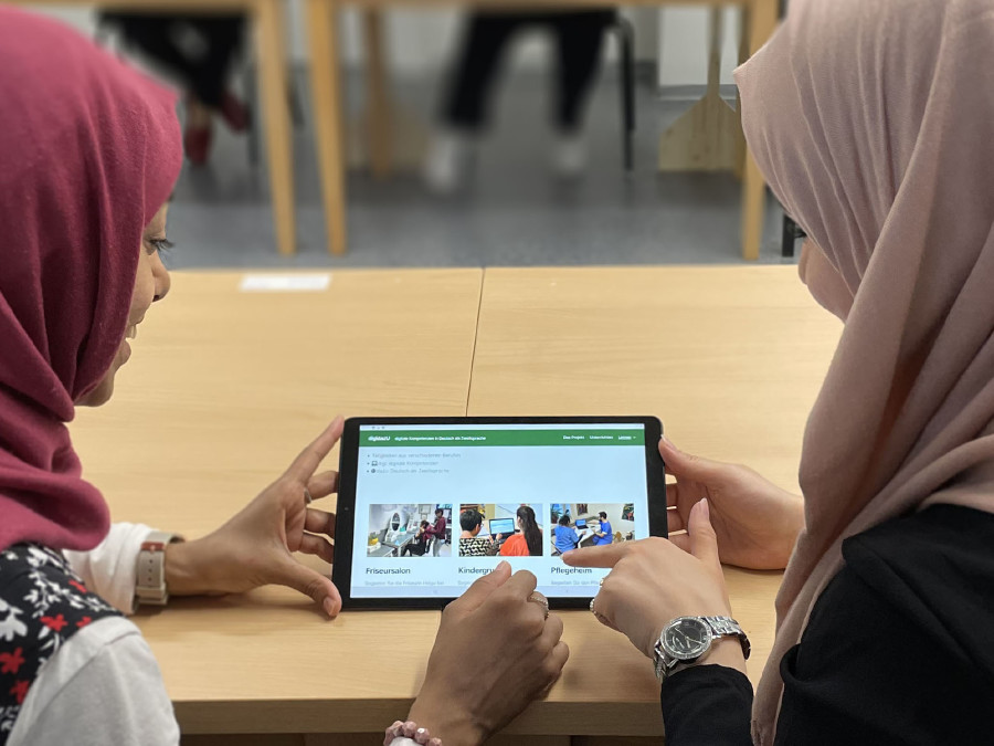 Zwei junge Frauen nutzen digidazU auf einem Tablet © Integrationshaus Zwei junge Frauen nutzen digidazU auf einem Tablet © Integrationshaus