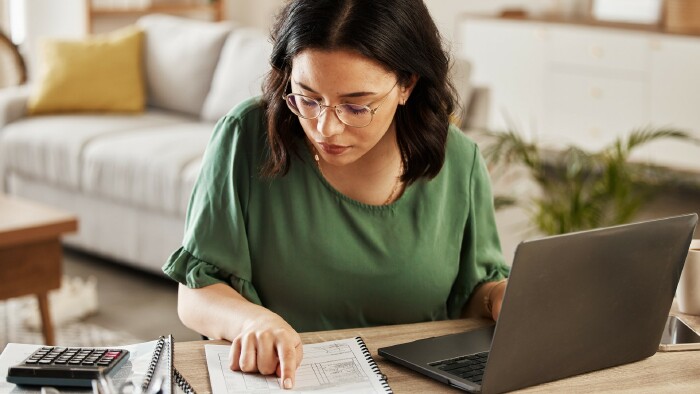 © Malik/peopleimages.com, stock.adobe.com Junge Frau beim Rechnen