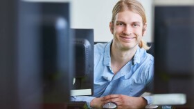 Junger Mann bildet sich mit Computerkurs fort