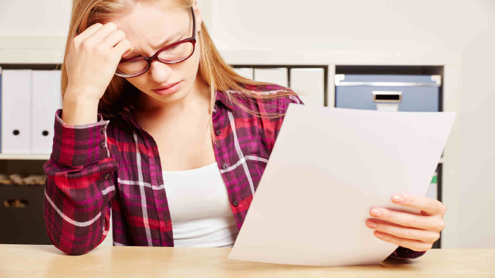 Frau mit Brief schaut besorgt © Robert Kneschke, stock.adobe.com
