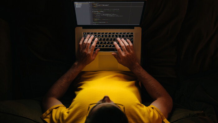 © Arsenii, stock.adobe.com Junger Mitarbeiter schreibt am Laptop spät in der Nacht.