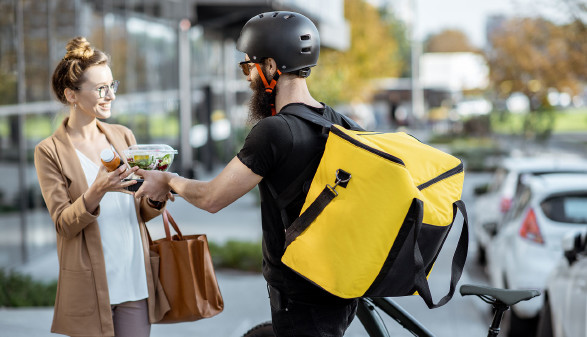 Fahrradbote bringt Kundin ihre bestellte Ware