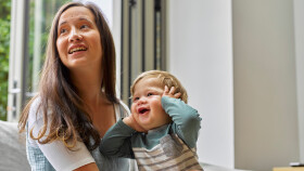Mutter mit lachendem Baby am Schoß