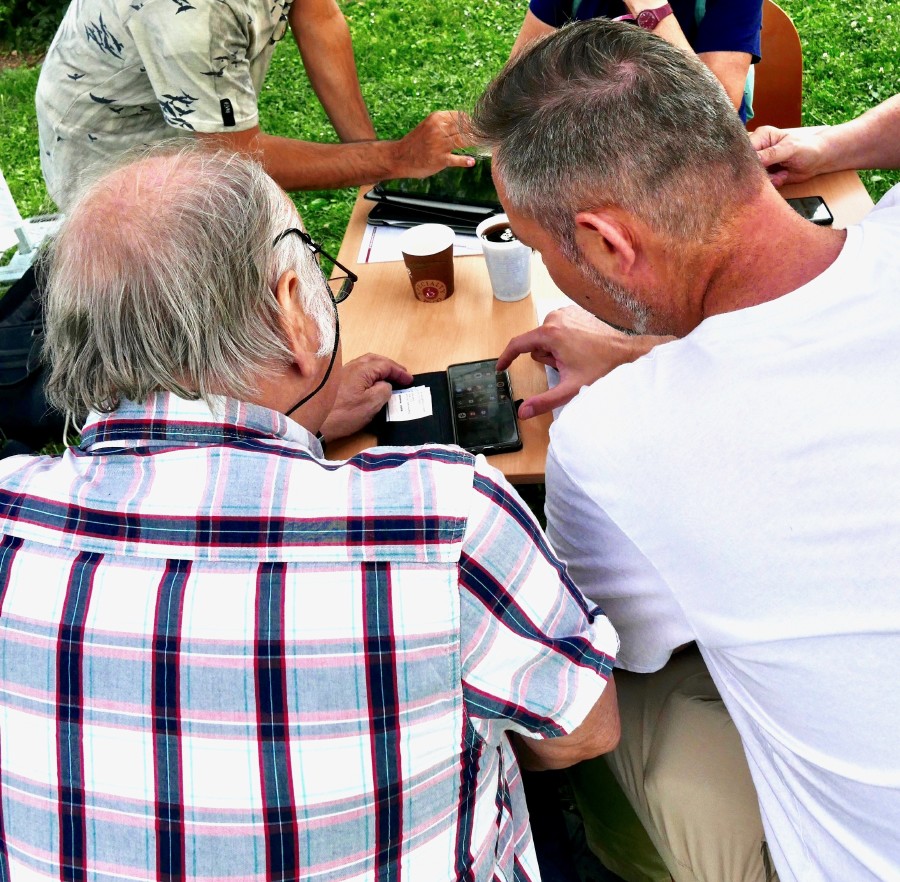 Einem älteren Herren wird bei Smartphone-Problemen geholfen