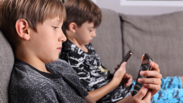 © Sabine Hürdler, stock.adobe.com 2 Buben blicken auf ihre Smartphones