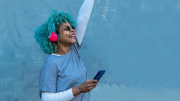 © carballo, stock.adobe.com happy young woman with headphones and mobile phone