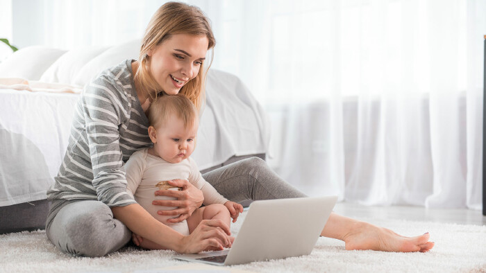 Frau mit Baby und Notebook