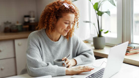 Frau sitzt bei Laptop