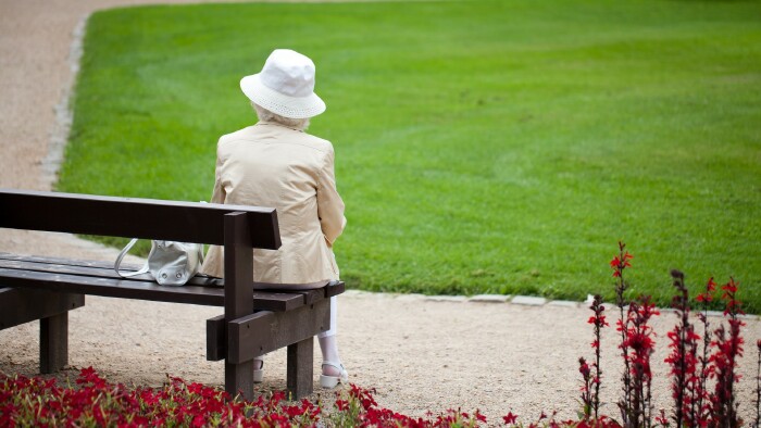 Alte Dame sitzt auf einer Parkbank