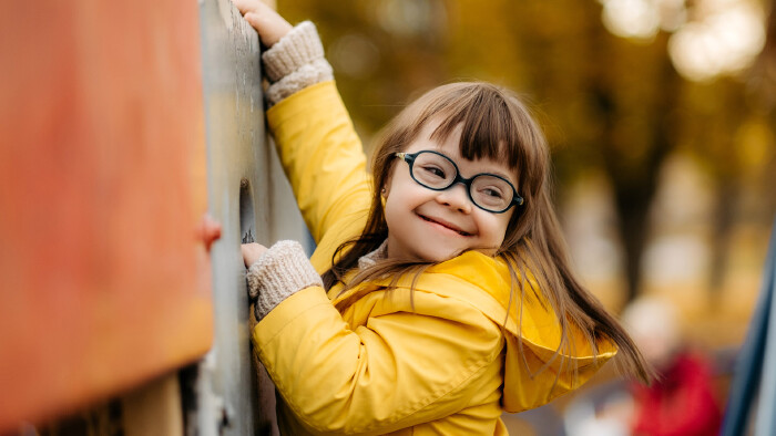 © sushytska, stock.adobe.com Glückliches Kind mit Down Syndrom geniest die Zeit am Spielplatz