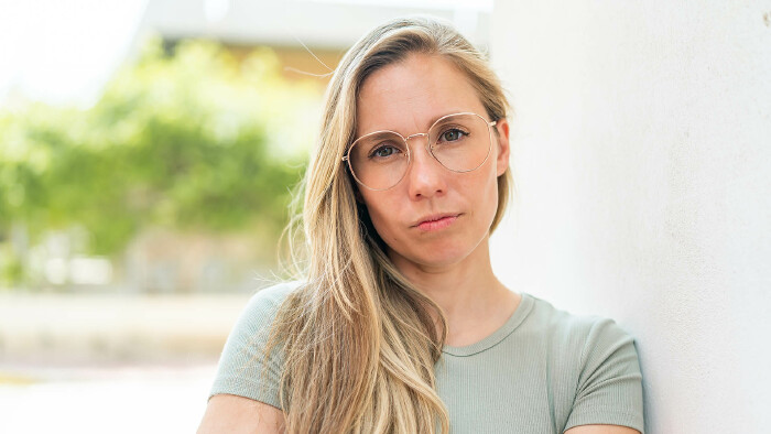 Frau mit Brille und verschränkten Armen