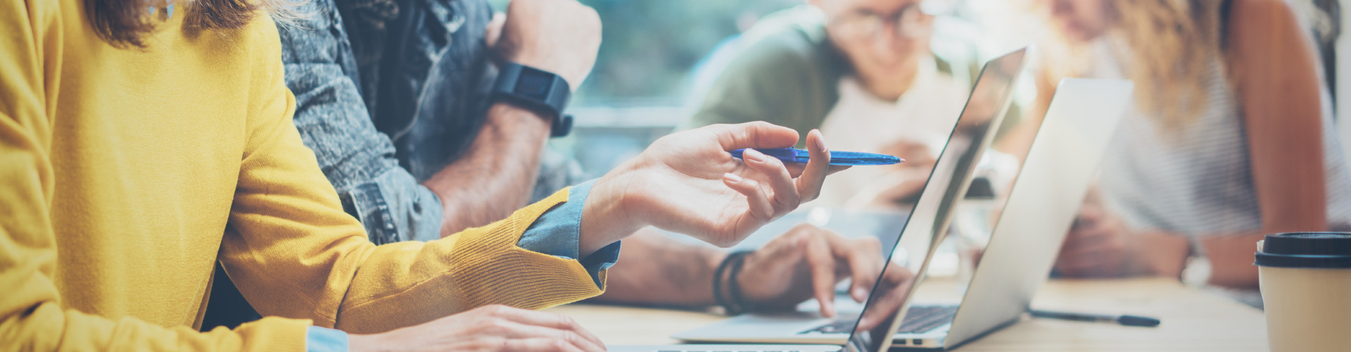 Mehrere Menschen sitzen gemeinsam mit Laptop an einem Tisch © Adobe Stock, Adobe Stock