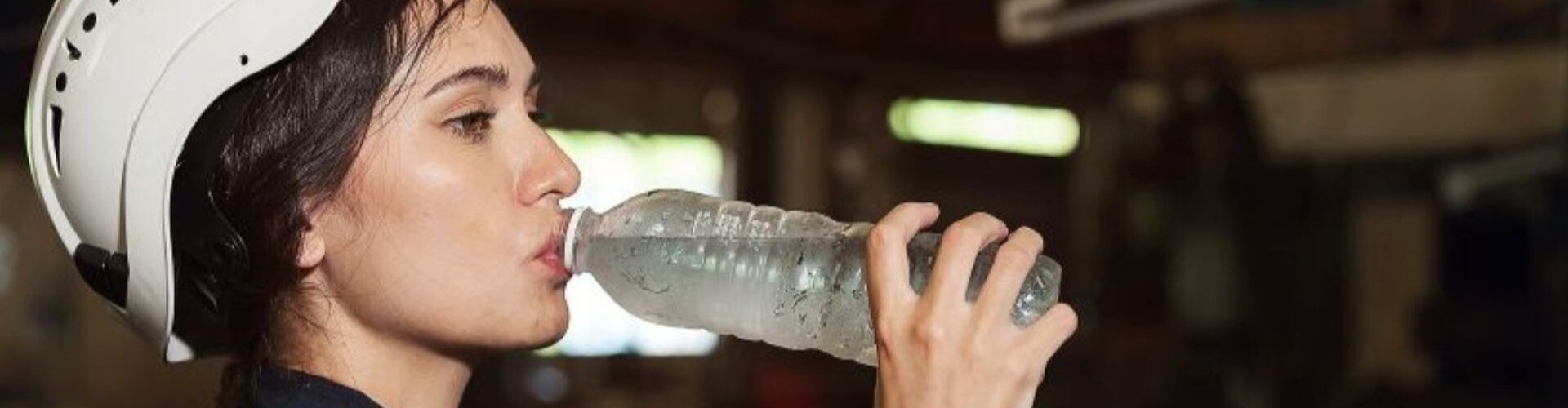 Junge Arbeiterin trinkt Wasser