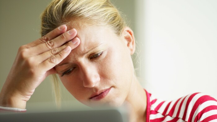 © Diego Cervo, stock.adobe.com Junge Frau hält sich den Kopf