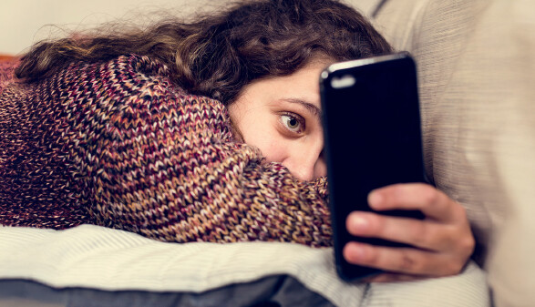 Junges M&auml;dchen surft am Smartphone.