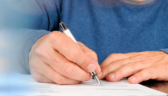 Mann unterschreibt Antrag