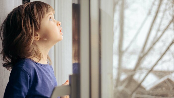 Mädchen schaut aus dem Fenster